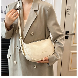 Chic cream semi-moon crossbody bag with litchi grain texture and gold buckle detail