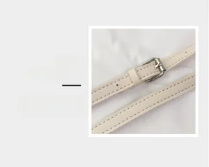 Detail of light beige leather strap with a polished silver metal buckle and neat stitching