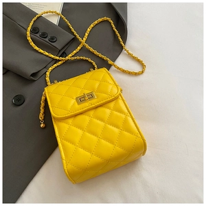 Close-up of a yellow quilted leather mini crossbody bag with golden chain and twist lock