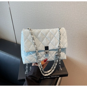 Nahaufnahme der hellblauen Stepptasche mit silberner Kette und metallischem Verschluss