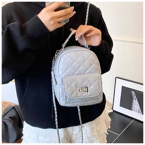Close-up of light blue quilted mini backpack with silver twist lock and chain strap detail