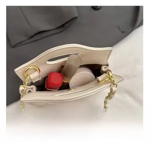 Detail showing the internal storage space for lipstick and cushion in the mini chain bag
