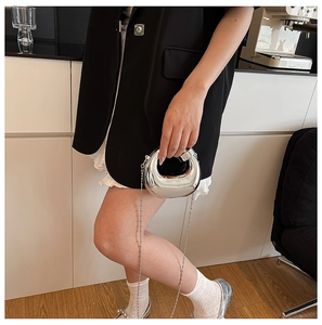 Mini borsa a mano argento specchiato con catena rimovibile mostrata da una modella