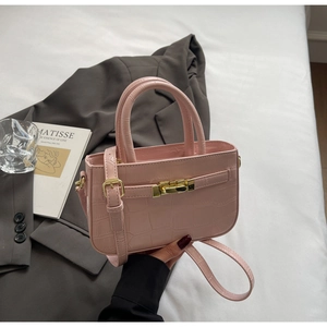 Detailed macro of pink crocodile texture faux leather bag with golden twist lock