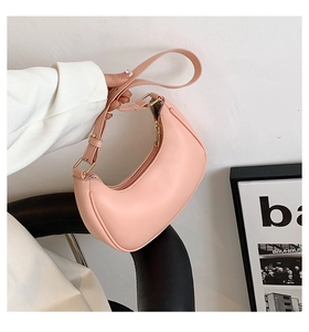 Detail of light pink moon-shaped hobo bag with smooth texture and matte gold zipper