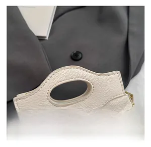 Detail of beige quilted leather mini bag with gold flower lock and chain strap
