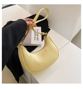 Detail of yellow crescent moon shoulder bag with adjustable strap and matte finish