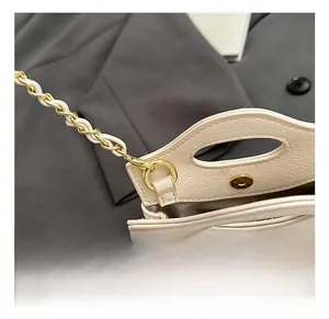 Close-up of golden chain strap and precise stitching on cream quilted mini bag
