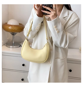 Mirror selfie showing a yellow hobo shoulder bag styled with a white blazer
