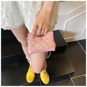 Detail of pink quilted mini bag showing gold flower buckle and metal chain strap