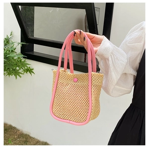 Detailed shot of pink woven handbag with intricate straw texture and snap button closure