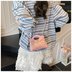 Rear view of a model wearing a pink quilted mini bag with golden flower clasp and chain