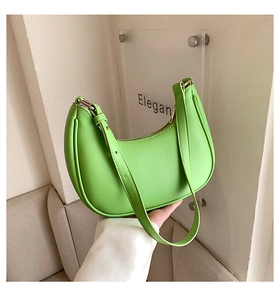 Detail of neon green crescent shoulder bag with smooth leather finish and gold buckle