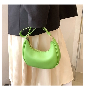 Detail shot of a vibrant green crescent moon shoulder bag with gold metal hardware