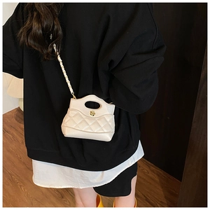 Mini quilted leather crossbody bag in cream white with floral metal buckle on model