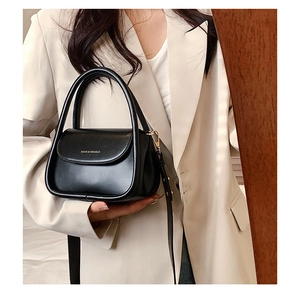 Chic black leather handbag for women featuring a minimalist flap and gold metal hardware