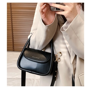 Chic black mini crossbody bag with gold Fashion & Bags print on a stylish beige blazer