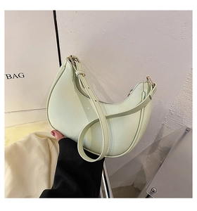 Close-up of mint green crescent moon bag with adjustable strap and gold hardware accents