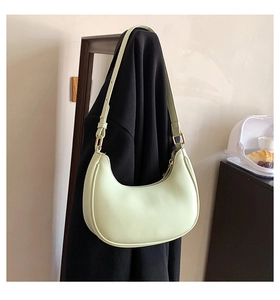Detail of light green crescent moon shoulder bag with gold zipper and matte texture