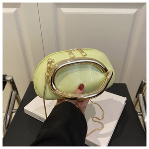 Detail of neon green patent leather handbag with gold metal handle and snake chain