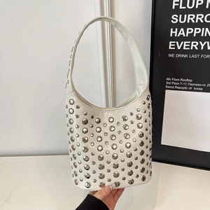 White rivet bucket bag with silver studs and circular handle in a minimalist style