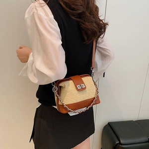 Fashionable straw patchwork crossbody bag with brown leather trim and metal chain