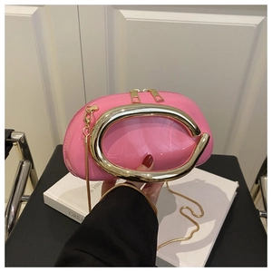 Pink glossy jelly evening clutch with a large gold circular metal handle and chain strap