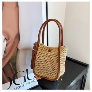 Close-up of woven straw texture and premium brown leather handle on a summer crossbody bag