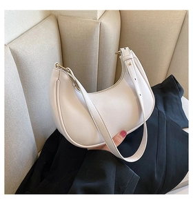 Detail of adjustable strap and smooth cream leather texture on the hobo shoulder bag