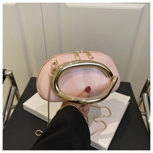 Detail of pink lacquer mini bag with oversized gold metal ring handle and chain strap