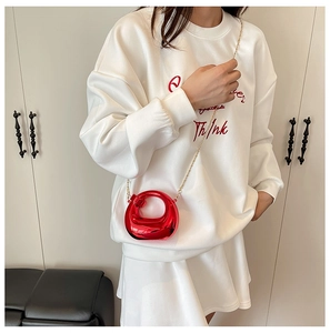 Dettaglio mini borsa a mano rossa metallizzata a U con elegante tracolla a catena dorata