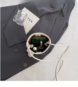 Interior view of off-white mini bucket bag showing capacity for phone and lipstick