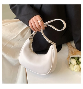Detail of white crescent hobo bag with adjustable leather strap and golden buckle