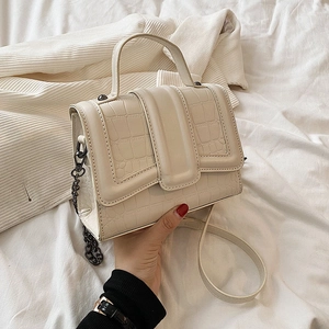 Borsa a mano bianco crema con stampa coccodrillo catena in metallo su sfondo morbido