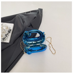 Dettaglio mini pochette blu specchiata con forma a simbolo unico e catena a sfere dorata