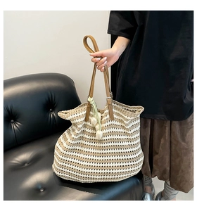 Detail of hand-woven striped tote bag with brown leather handle and tulip pendant