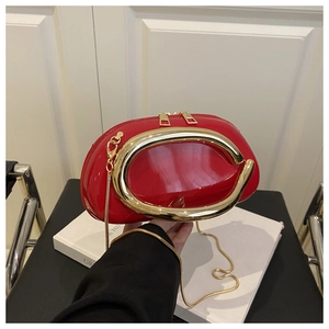 Detailed view of glossy red semi-circle clutch with golden C-handle and chain strap