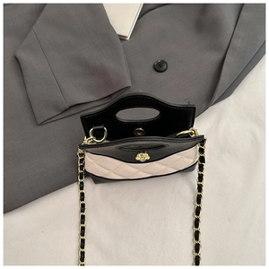 Detail of quilted mini bag featuring golden camellia clasp and woven chain strap