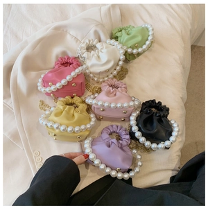 Detailed close-up of mini pleated cloud bags with pearl handles in various vibrant colors