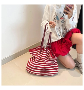Detail of red and white striped hand-woven crochet tote bag with adjustable leather straps