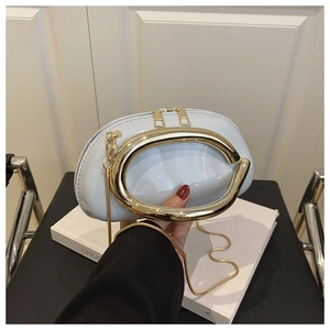 Detail of light blue patent leather bag with large gold handle and fine chain strap