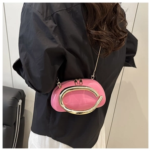 Close-up of pink patent leather mini bag with large gold metal ring and chain strap