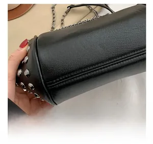 Detail der präzisen Nähte und Silbernieten am Boden der schwarzen Ledertasche