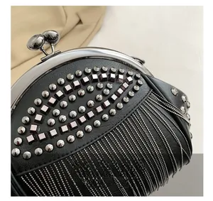 Detail der schwarzen Ledertasche mit silbernen Nieten und Metallketten-Quasten