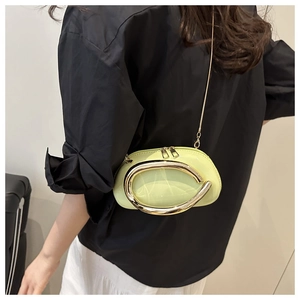 Detail of light green patent leather pillow bag with gold hardware and metal chain strap