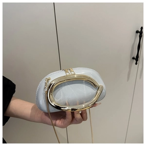 Detail view of light blue patent leather clutch with large gold ring handle and chain strap
