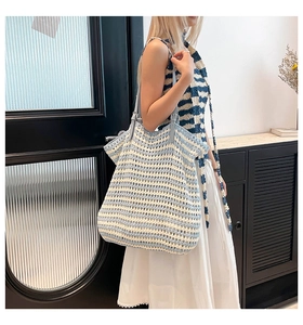 Detail of blue and white striped hand-woven tote bag with adjustable leather strap