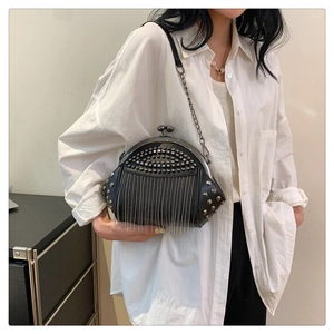 Modische schwarze Muscheltasche mit silbernen Nieten und Metallquasten am Modell