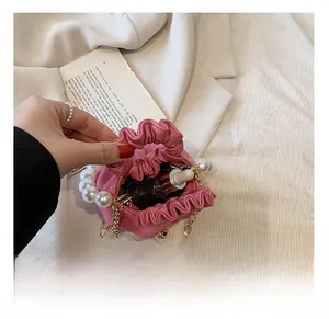 Detail view of pink pleated mini bag with pearl handle and golden chain interior capacity