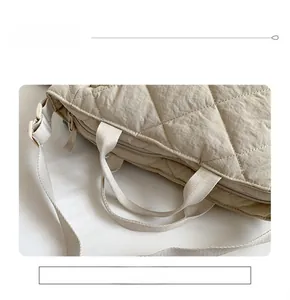 Détail du sac cabas matelassé beige montrant les poignées et la fermeture éclair